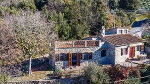 A stone house with a balcony and a view of a mountainous landscape. - Wonderful private villa for 6 people with hot tub, WIFI, terrace, pets allowed and panoramic view (Castellina Marittima)