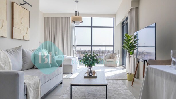 Een moderne woonkamer met een bank, salontafel en een groot raam met uitzicht op de stad.