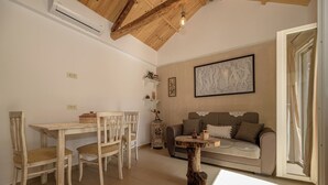 Un salon chaleureux avec un plafond en bois, un canapé, une table à manger avec des chaises et un élément décoratif mural.