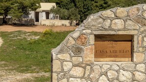 Une petite maison en pierre avec une enseigne en bois indiquant : « CASA ABUELO ».