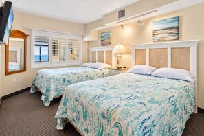 A hotel room with two beds, a television, a window with blinds, and a painting on the wall. - Oceanfront Condo with Resort Pools (North Myrtle Beach)