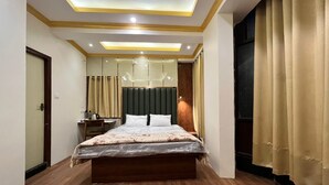 Une chambre à coucher moderne avec un lit en bois, un bureau et un grand miroir.