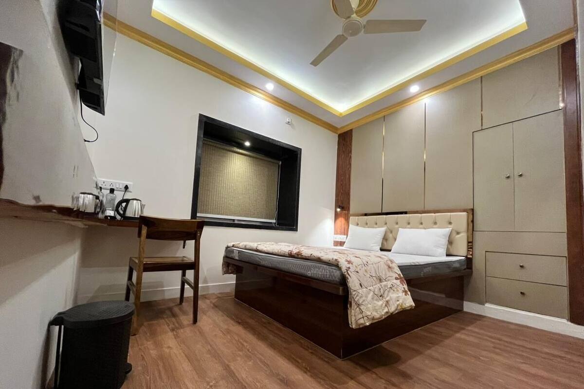 Quarto com cama, mesa de cabeceira e guarda-roupa.