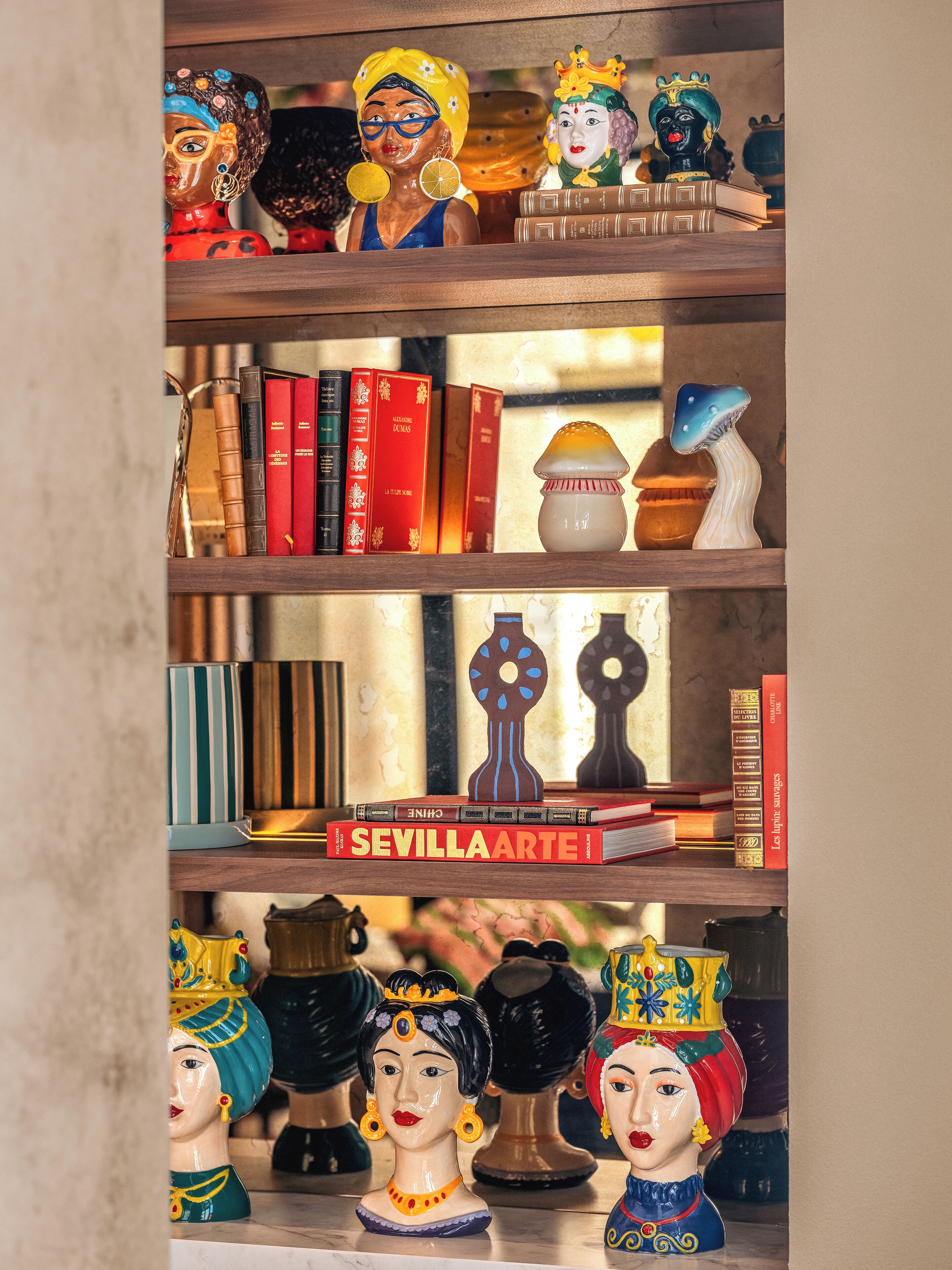 A shelf with books, decorative items, and figurines.