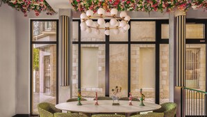 A round table with six chairs, a chandelier, and decorative items. - Chachacha Hôtel (Nantes)