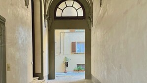 A corridor with stone flooring and ornate arches. - Charming 2-bedroom apartment in lovely Firenze with AC, WiFi (Florence)