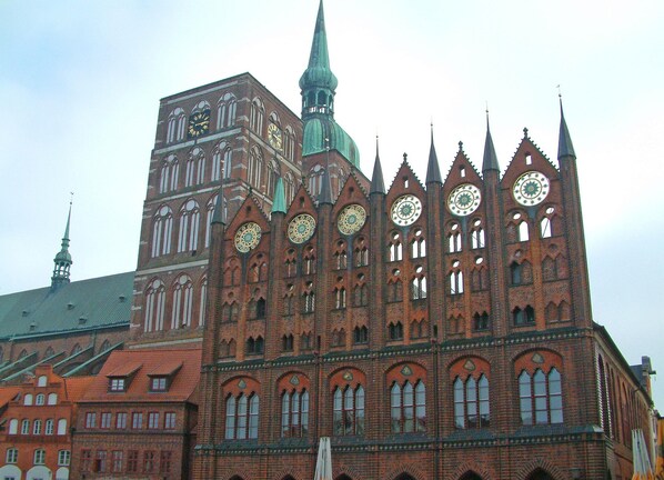 A historic building with multiple spires and large clocks, featuring Gothic architecture. - Ferienwohnung Kranichring in Negast Nahe Stralsund (Steinhagen)