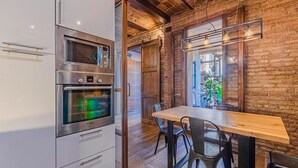 Une cuisine équipée d’un four moderne, d’une table à manger en bois et de chaises.