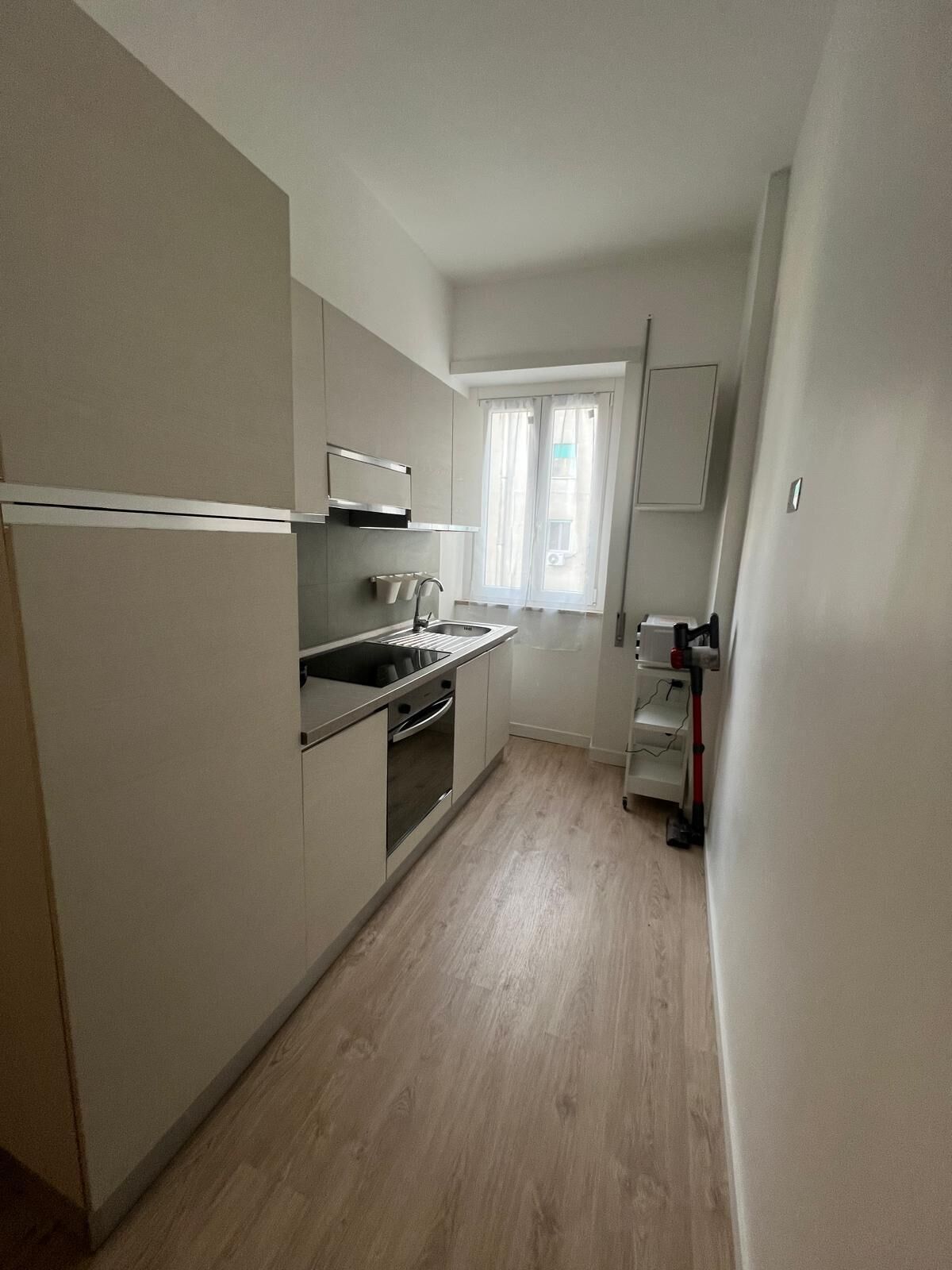 Moderni keittiö, jossa on sisäänrakennettu uuni, mikroaaltouuni ja pesuallas.