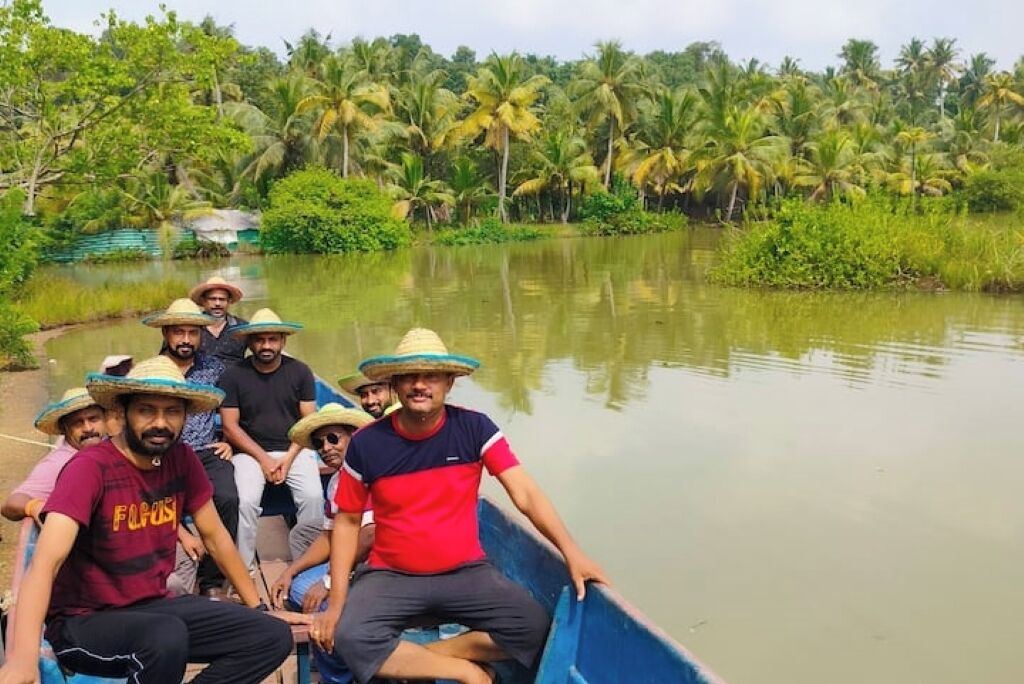 Un groupe de personnes se trouve dans un bateau bleu sur une rivière paisible, entourée d’une végétation luxuriante.
