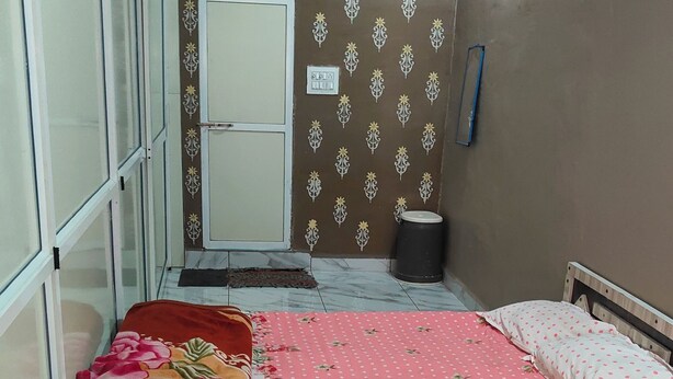 A bedroom with a bed, a window, a door, and a ceiling fan.