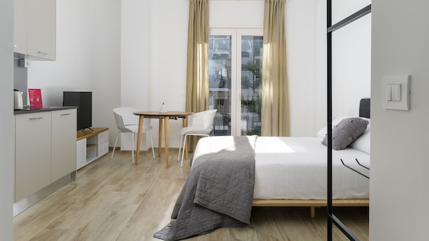Un dormitorio moderno con cama, escritorio y silla.