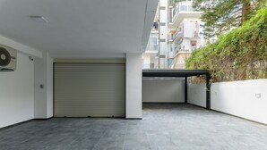 Un apartamento moderno con puerta de garaje cerrada, un ventilador y vistas de edificios vecinos.