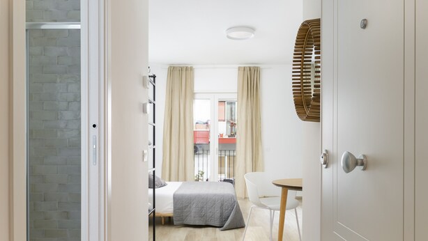 A hotel room with a bed, a chair, a small table, and a window with curtains. - Palazzo Murat - Apartment With City View by Wonderful Italy (Bari)