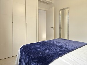 A bedroom with a bed, a wardrobe, and a door. - Ipanema near La Cala de Mijas (Mijas Costa)