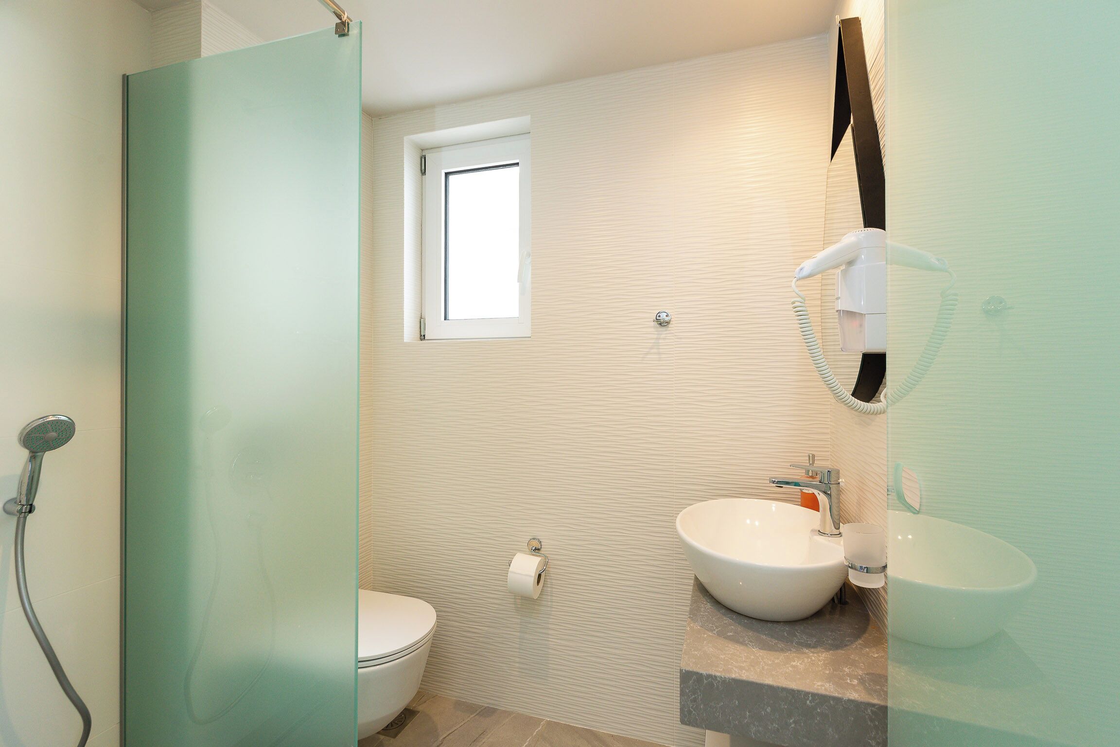 A bathroom with a toilet, bidet, and two sinks.