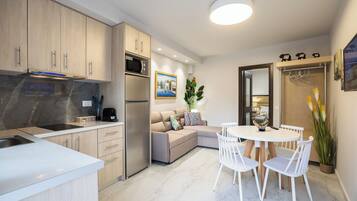 A modern kitchen with a built-in microwave, a stainless steel refrigerator, and a white countertop.