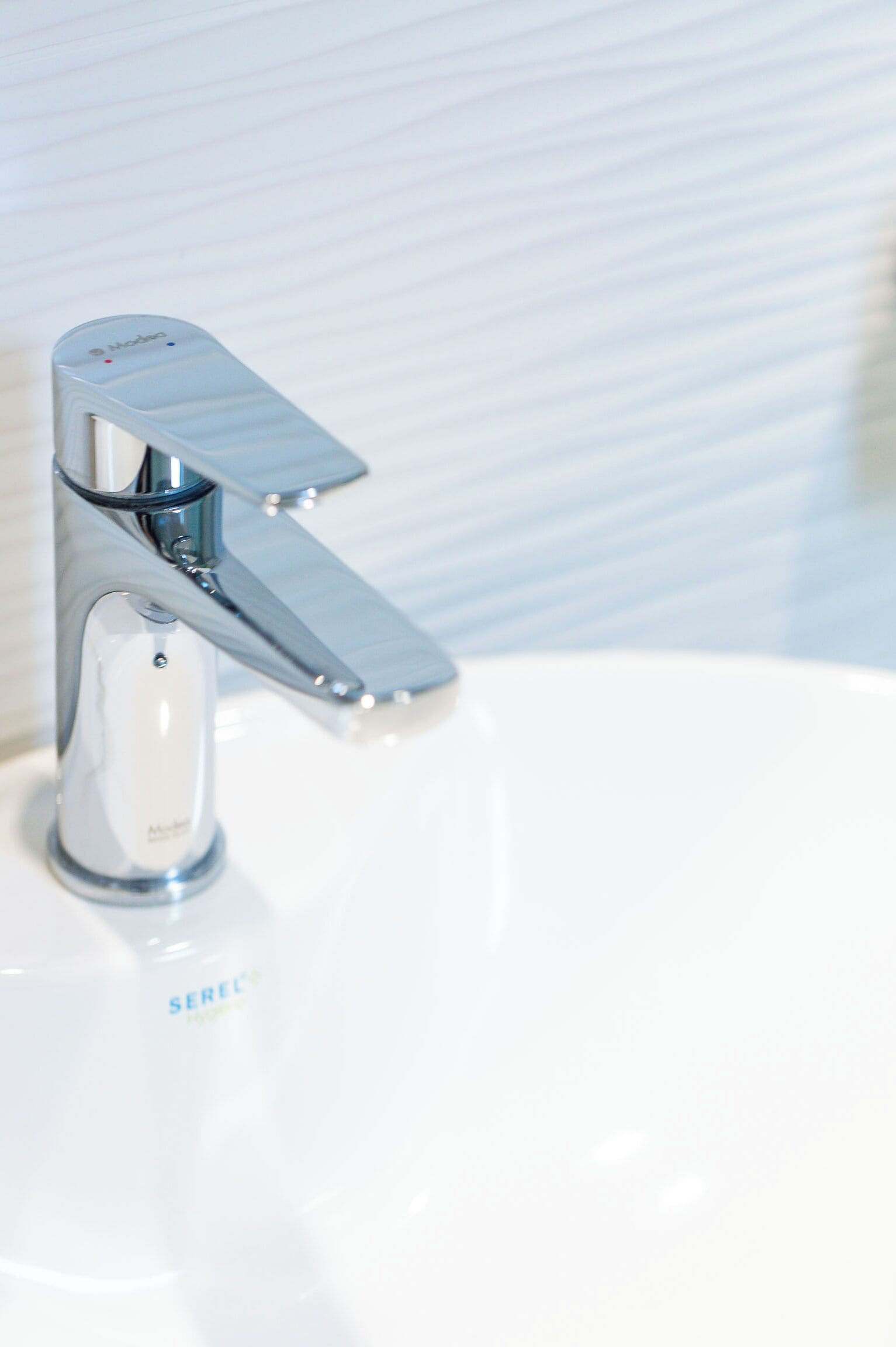 A modern bathroom sink with a chrome faucet and a white basin.