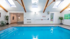 A swimming pool with skylights, a door, and a view of the outside. - Pet friendly Croft Cottage (Truro)