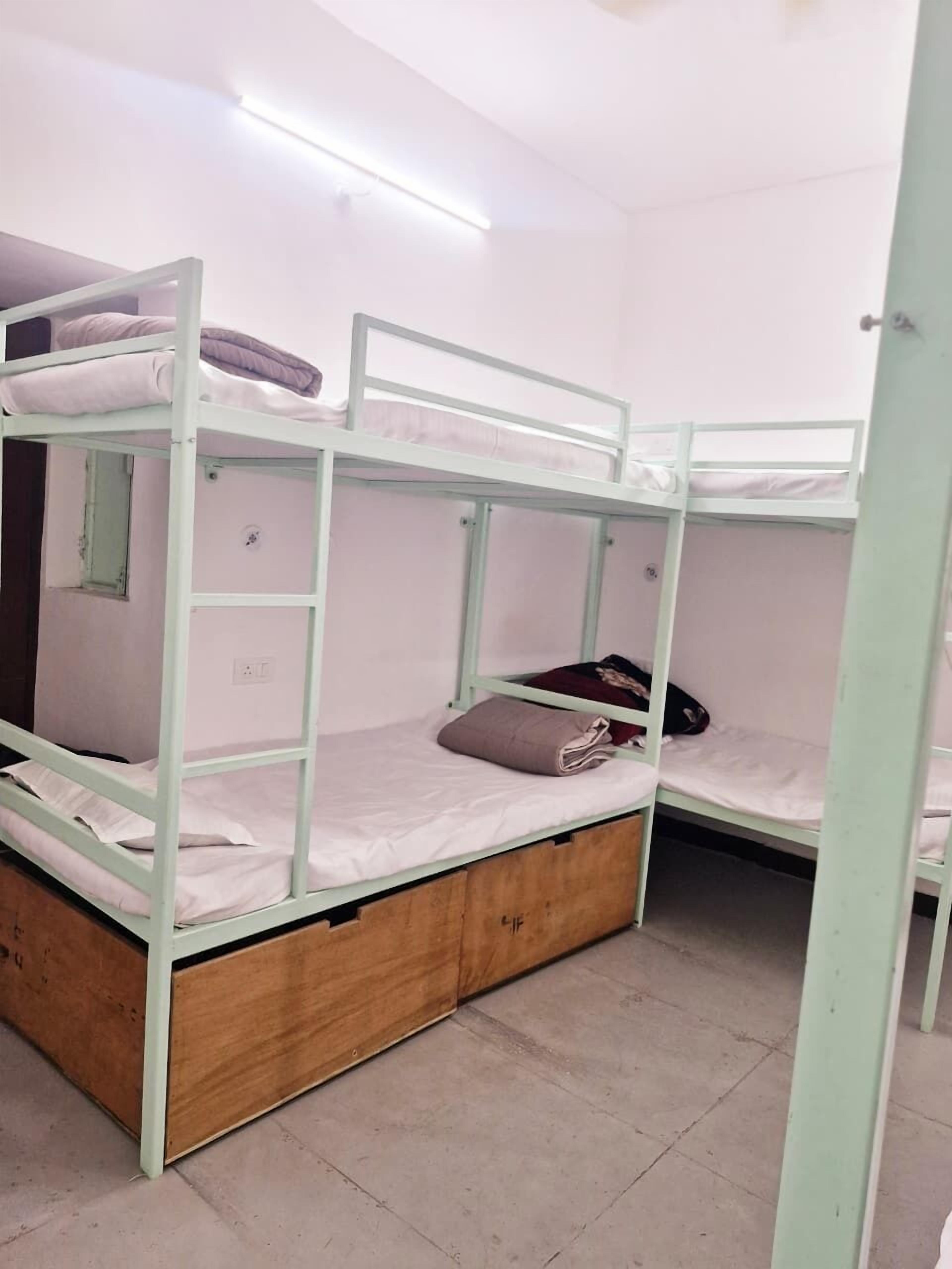 A bunk bed room with a wooden platform and a small window.