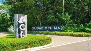 Señal de Ciudad Del Mar con un símbolo de estrella y un acceso ajardinado.