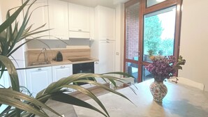 Eine moderne Küche mit weißen Schränken, einer Holz Arbeitsplatte und einem großen Fenster mit Blick auf Grünflächen.