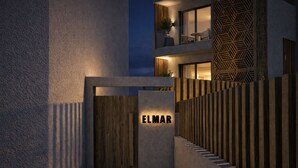 Une entrée moderne avec une porte en bois portant l’inscription « ELMAR ».