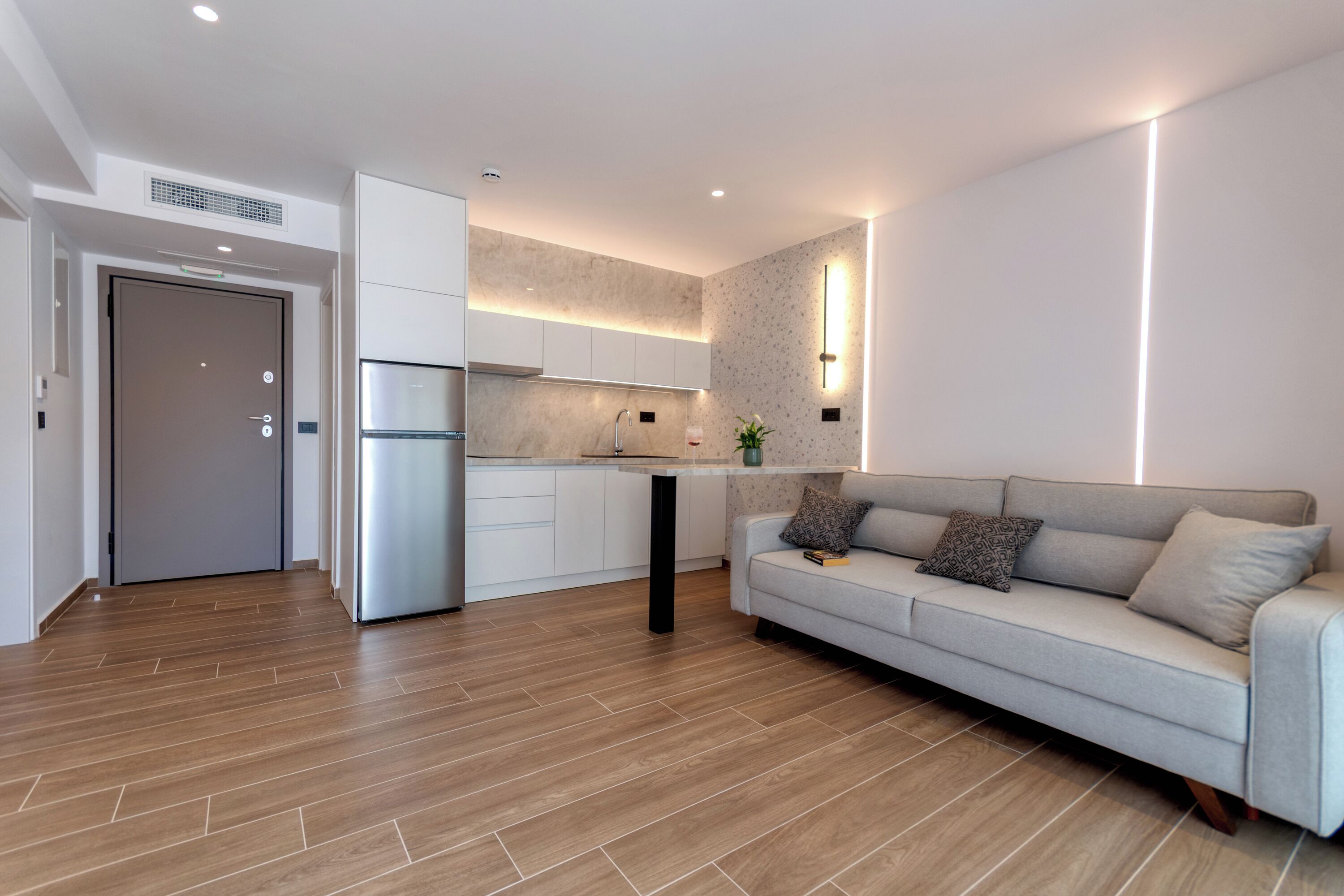 A modern kitchen with white cabinets, a built-in oven, and a countertop.