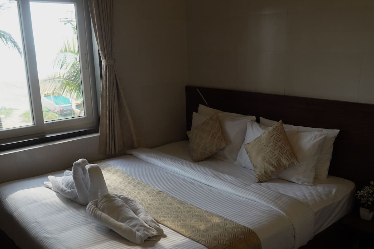 A neatly made bed with a headboard, pillows, and a blanket.