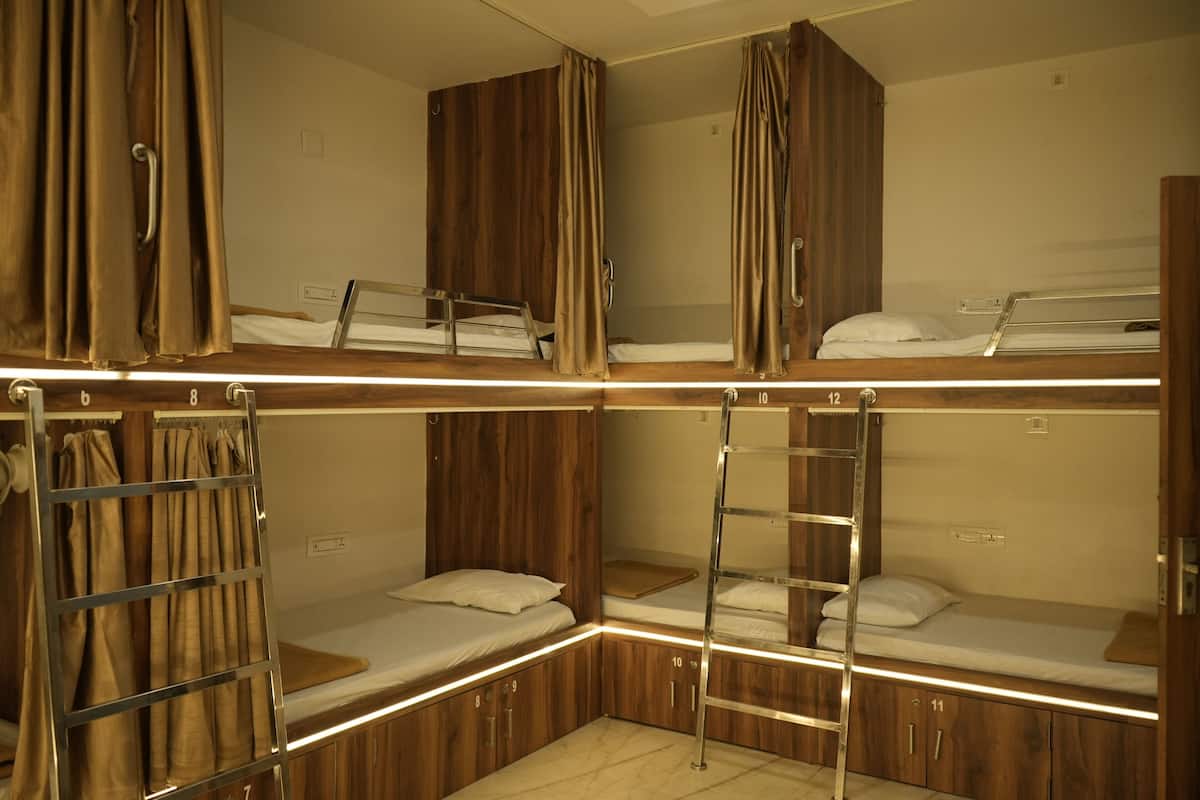 A bunk bed room with wooden walls, a ladder, and curtains.
