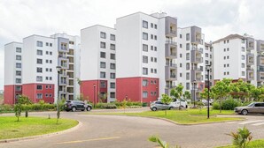Ein moderner Wohnkomplex mit mehreren Gebäuden, einer zentralen Straße und Grünflächen.