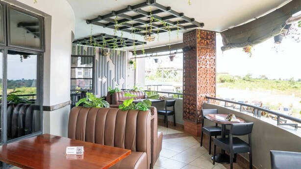 Ein Restaurant mit Terrasse, Ledersitzgelegenheiten und hängenden Pflanzen.