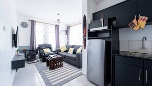 A modern apartment with a living room, kitchen, and dining area.