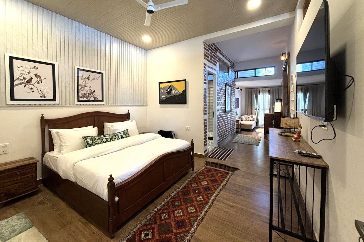 A bedroom with a wooden bed, a ceiling fan, and artwork on the walls.