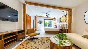Una sala de estar moderna con un sofá, una mesa de centro con plantas, un televisor y una estantería de madera.