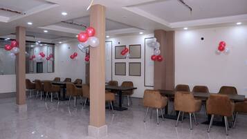 A conference room with tables and chairs, balloons, and a polished floor.