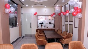 A conference room with a long table and several chairs, decorated with balloons. - Hotel Subhadra (Kannauj)