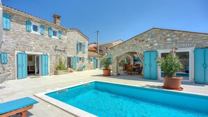 A stone building with a swimming pool, outdoor seating, and potted plants. - Lovely home in Selina (Selina)