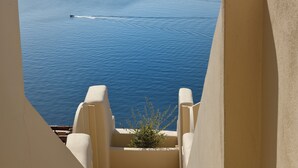 Blick vom Balkon auf ein Gewässer mit einem Boot, das eine Bugwelle hinterlässt.