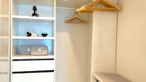 A walk-in closet with white shelving, a drying rack, and a few hangers. - w Impeccable 2BR w Charming Balcony in CTG (Cartagena)