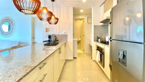 A modern kitchen with a central island, stainless steel appliances, and pendant lighting. - w Impeccable 2BR w Charming Balcony in CTG (Cartagena)