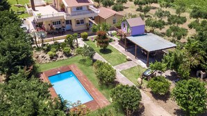 A two-story house with a swimming pool, a covered patio, and a vineyard in the background. - Laylande House with Private Pool (Theologos)