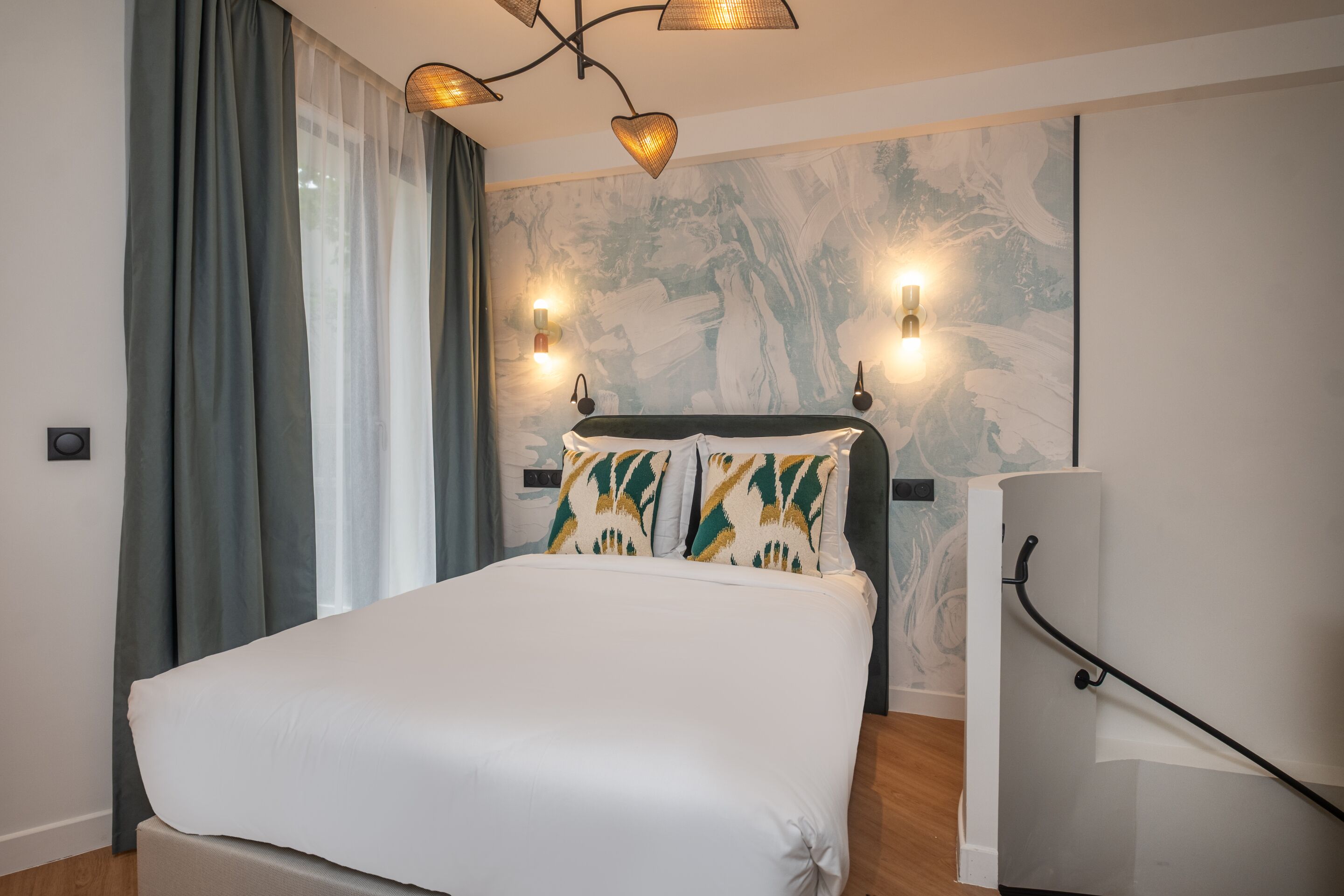 A modern bedroom with a large bed, a headboard with wall-mounted lights, and a mural on the wall.