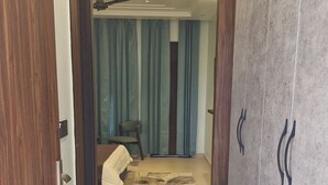 Un pasillo que conduce a una habitación con ventilador de techo, una silla y una alfombra.