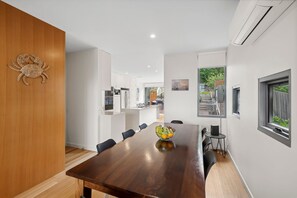 Een moderne eetruimte met een houten tafel, stoelen en een fruitschaal.