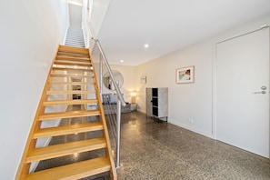 Een trap met een houten leuning die naar een verdieping leidt.