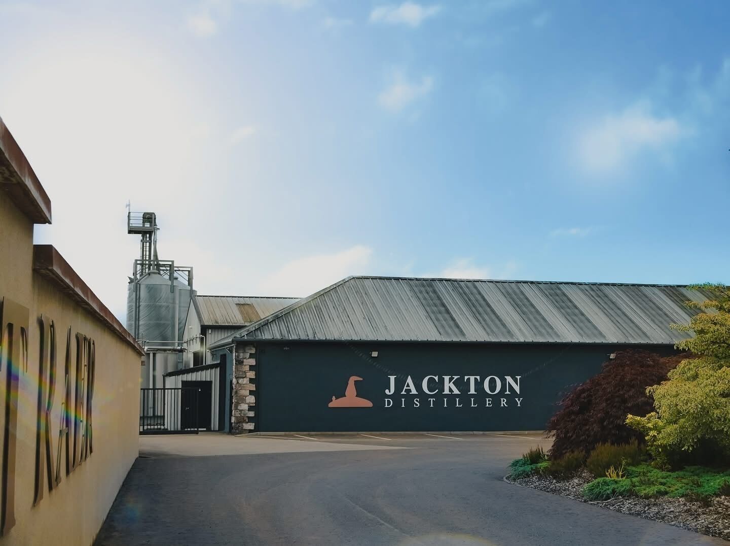 Un edificio de destilería con un gran letrero que dice 'Jackton Distillery'.