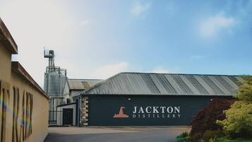 Un edificio de destilería con un gran letrero que dice 'Jackton Distillery'.