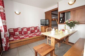 A compact living space with a sofa, a dining table, and a television. - 100m from resort center, tv, 21m², Tignes (Tignes)