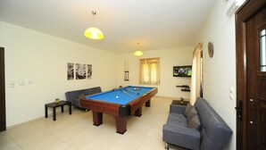 A living room with a pool table, a sofa, and a television. - Villa Orsalia With Private Pool (Rethymno)